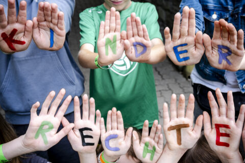 Kinderrechte mit Fingerfareben auf Kinderhänden