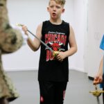 Teilnehmer inszenieren ein filmisches Schwertduell mit Lichtschwert und Degen beim Kinderworkshop Epische Film-Duelle in Duisburg