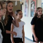 Teilnehmende beim Warm-up im Theaterworkshop Marl üben Körperausdruck und Bewegung für ihre Rollen.