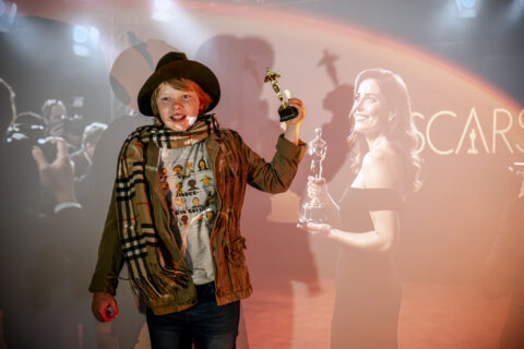 Workshopteilnehmer posiert vor Projektion von Oscarverleihung