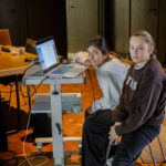 Kinder und Jugendliche betrachten gemeinsam ihre entstandenen Fotos auf dem Laptop im Workshop Fake It Dinslaken