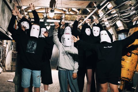 Jugendliche posieren mit Masken für das Musikvideo