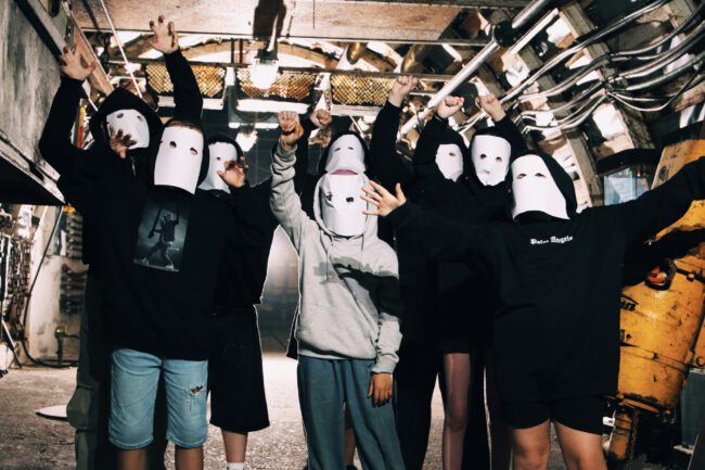 Jugendliche posieren mit Masken für das Musikvideo